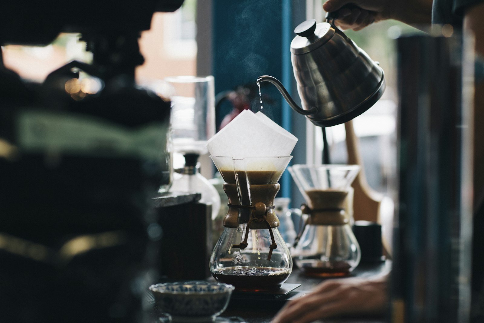 Pour-over coffee being brewed through a paper filter with a gooseneck kettle