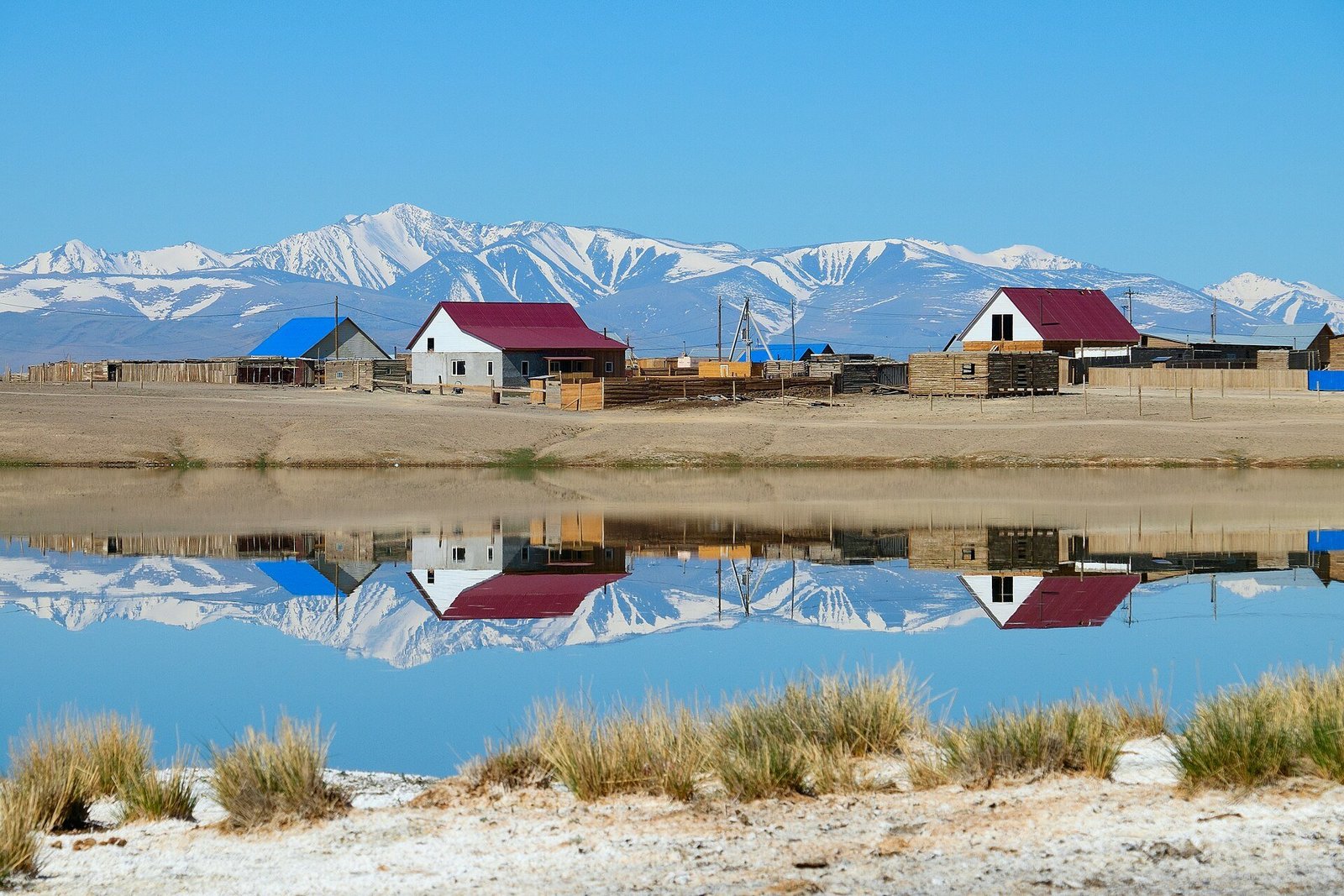 Wide view of the village of Kosh-Agach on the flat, dry Chuya steppe with the Altai mountains behind it