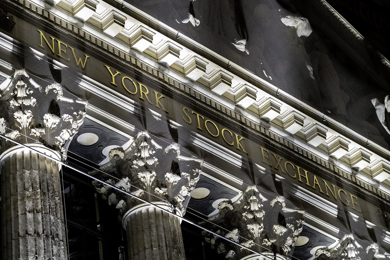 The New York Stock Exchange name carved above its columns at night