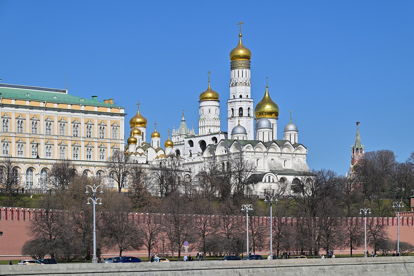 The red walls and towers of the Moscow Kremlin seen across the river on a clear spring day